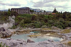 Blue pool with Hotel Geyserland in background at Te Whakarewarewa